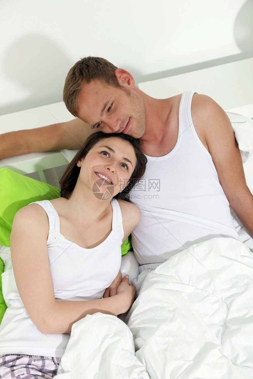 床上快乐的年轻夫妇女性情绪夫妻男人家庭拥抱闲暇睡衣幸福白色图片