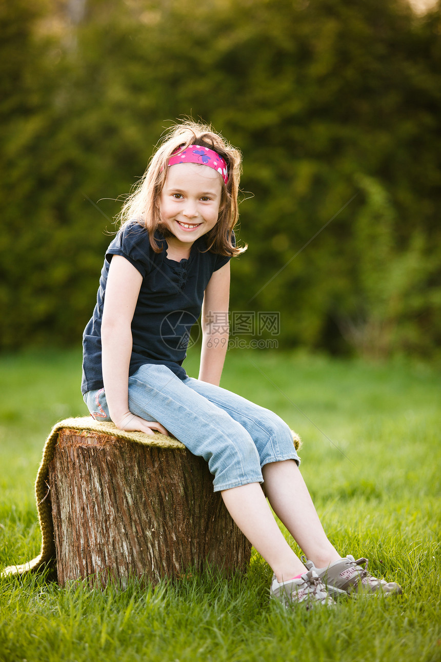坐在树干上的女孩孩子女性童年太阳黄金时段微笑图片