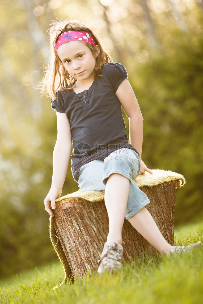 坐在树干上的女孩童年女性孩子太阳微笑黄金时段图片