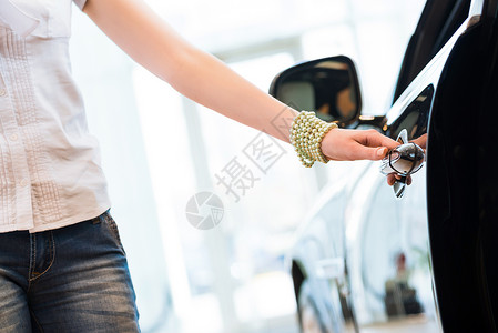 开口手镯女人打开新车的门手镯消费者女性手臂陈列室汽车司机运输女士手表背景