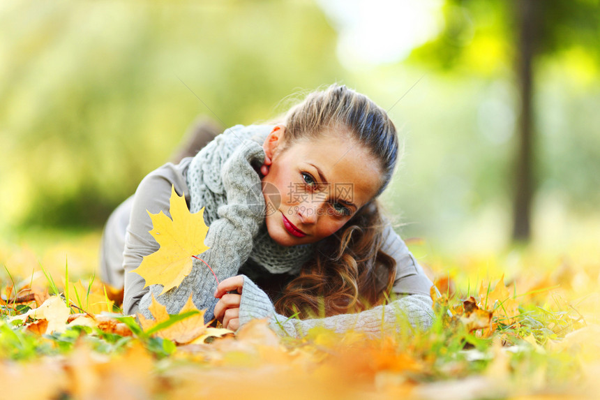 秋叶中的妇女脚尖公园幸福季节微笑乐趣橙子成人眼睛女性头发图片