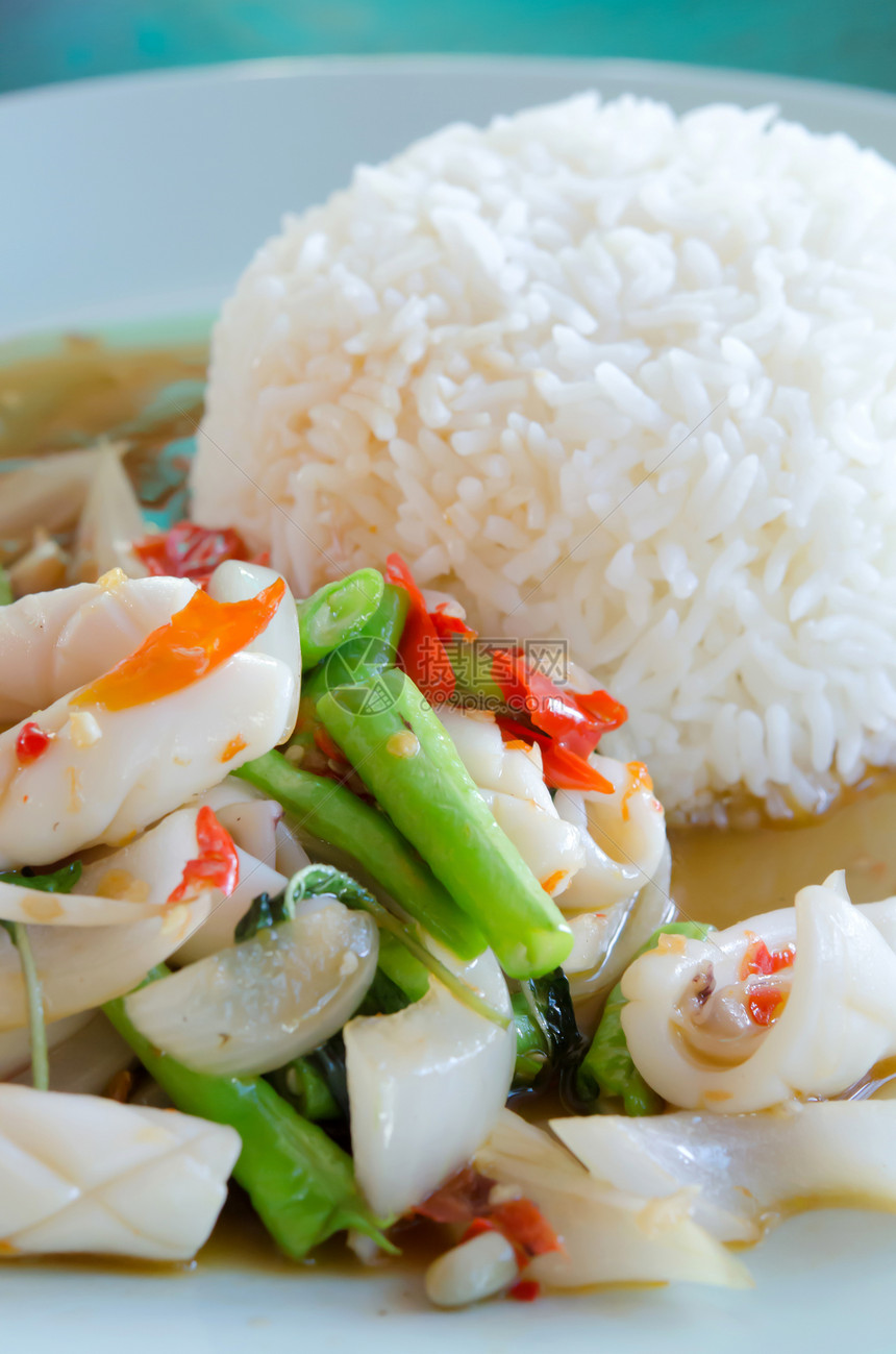 鱿鱼和大米章鱼白色盘子油炸绿色蔬菜红色海鲜美食辣椒图片