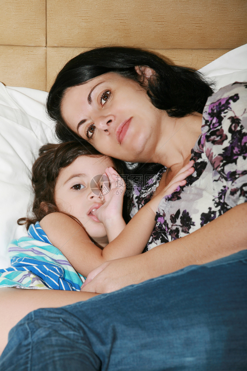 美丽的年轻母亲和她女儿在床上睡觉图片