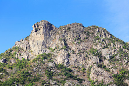 禁鸣喇叭香港的狮子岩石山蓝色喇叭绿色爬坡草地岩石天空植物背景