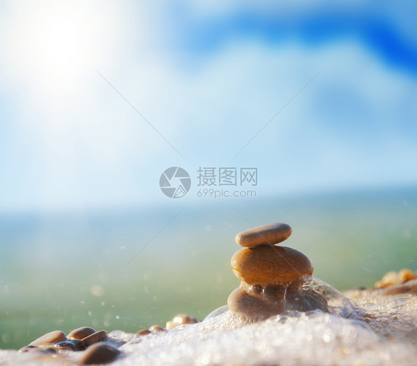 海滩上的石头支撑海滨岩石卵石平衡矿物精神命令蓝色温泉图片