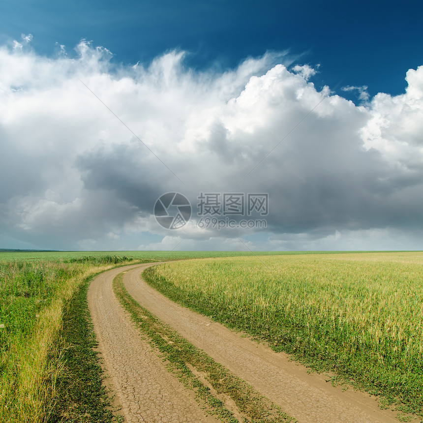 田野中的肮脏的道路 地上的低云;图片