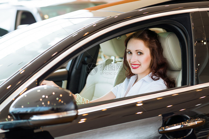 女青年在展厅的新车里学习欢乐驾驶人士成就车辆旅行考试幸福运输图片