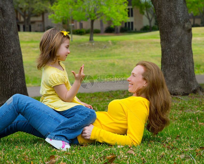 女儿和母亲在草坪上玩着数以计数的游戏公园金发花园童年孩子闲暇乐趣场地手势女士图片