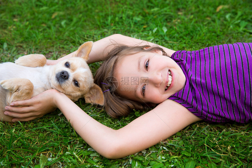 女孩在草坪上玩吉华小狗友谊草地婴儿朋友犬类幸福吉祥物别针毛皮说谎图片