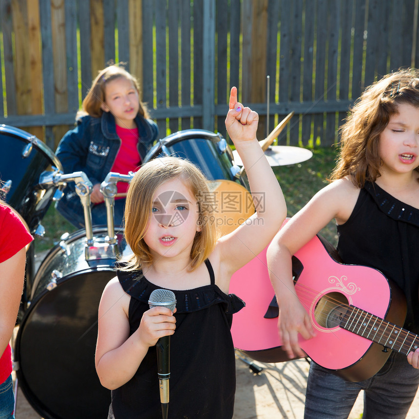 歌唱女歌手在后院现场演奏乐团音乐家岩石享受孩子们闲暇音乐玩家栅栏音乐会团体图片