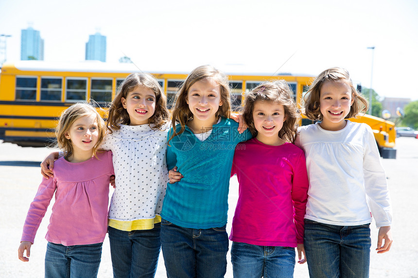 校内女学生朋友在校车旁行走拥抱孩子们邻里学者教育乘客童年女性幸福旅行图片