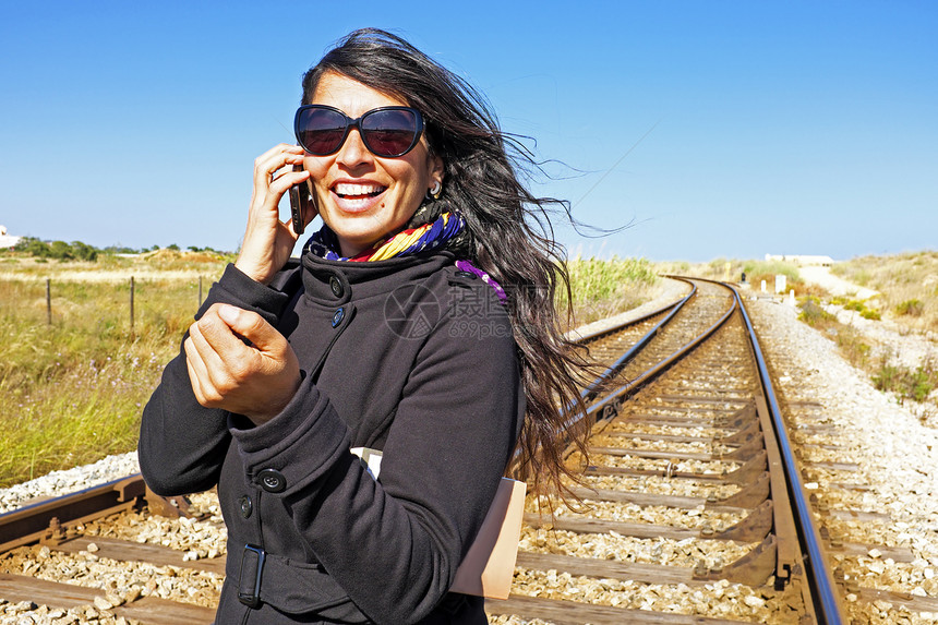 年轻美女在铁路赛道上打来电话图片
