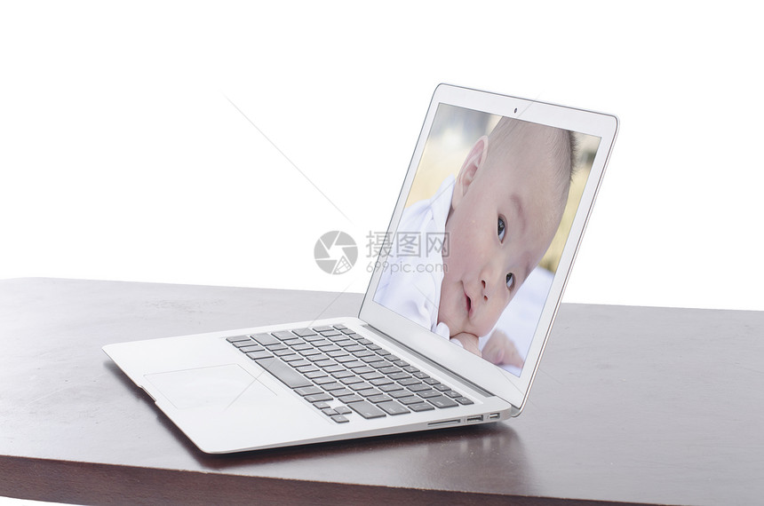 笔记本电脑上婴儿照片屏幕技术男人键盘电子网络工作桌子推介会幻灯片图片