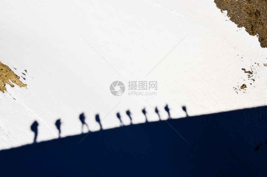 雪上一群山中登山者的影子图片