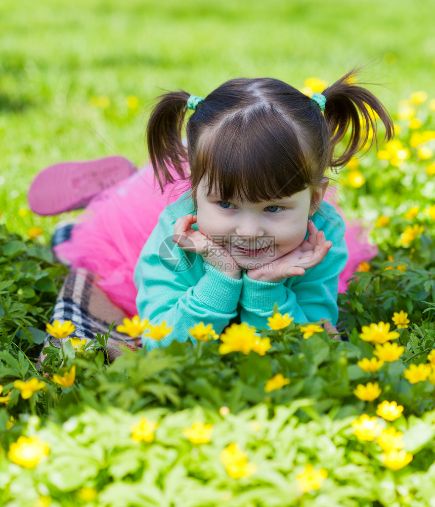 小女孩躺在草地上空地谎言家庭休息公园孩子日光太阳能图片