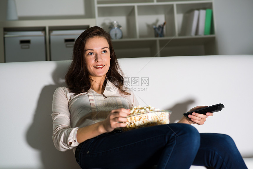 女青年看电视微笑控制客厅沙发技术女性长椅相机快乐屏幕图片