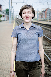 年轻美丽时装女士走路城市生活女子微笑头发铁路皮肤城市车站背景图片