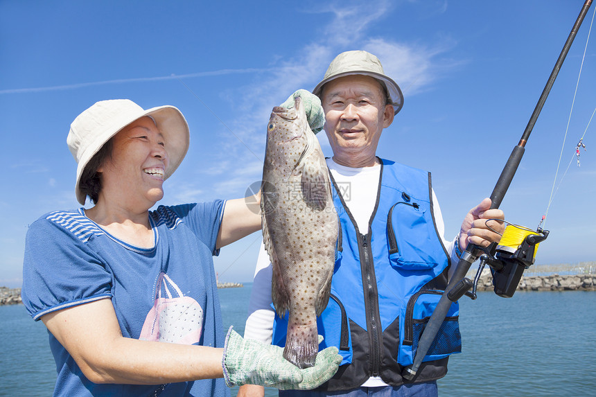 高龄亚裔夫妇钓鱼和展示大型粉丝图片