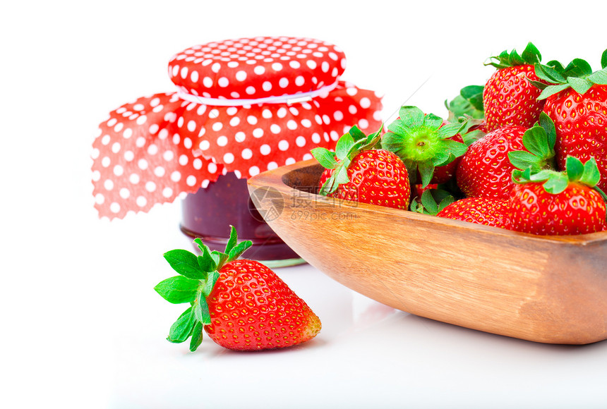 在木碗里放着草莓浆 和一罐果酱图片