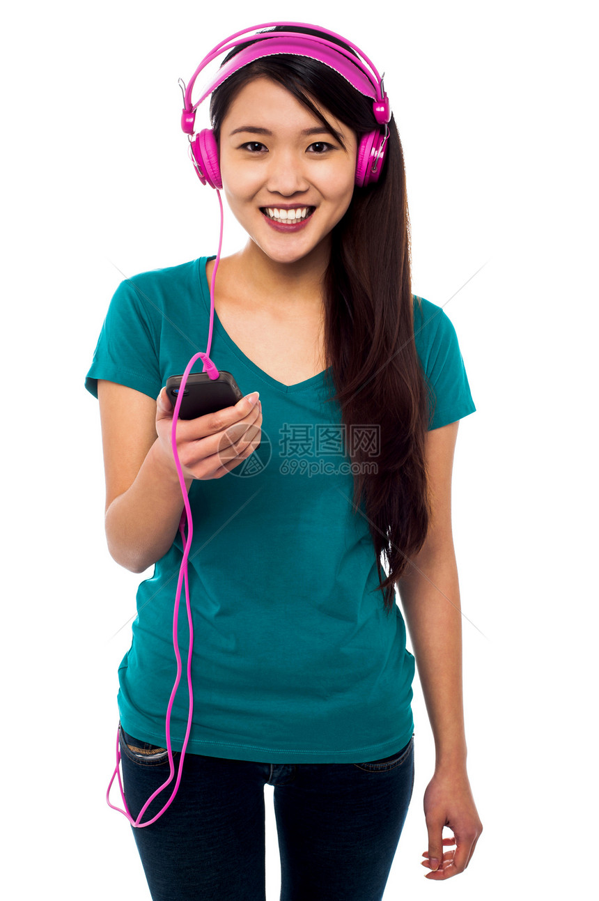 听音乐的漂亮女孩粉色岩石享受调谐音乐女孩牛仔裤微笑歌曲女性化图片