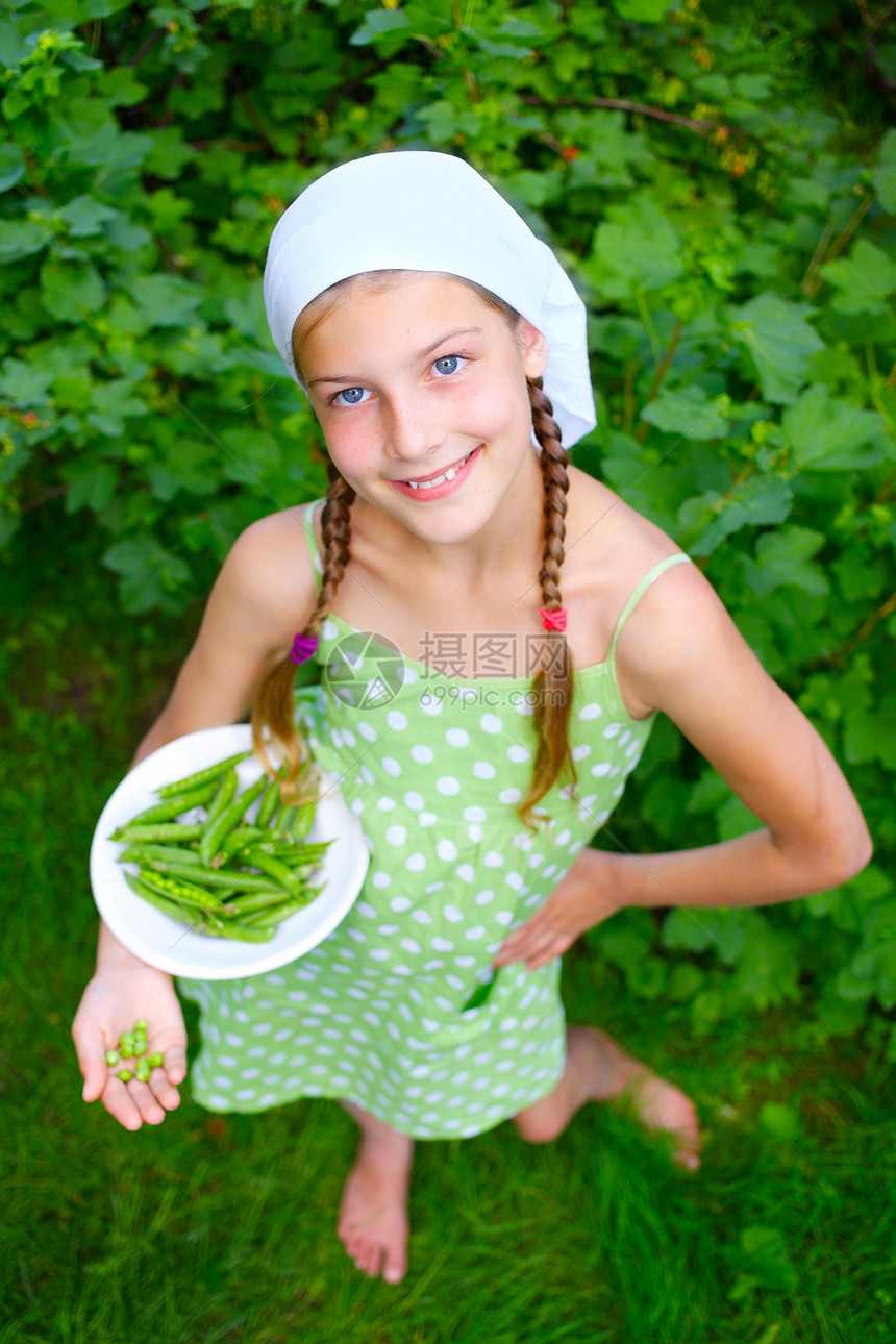 持有绿色青豆的女孩食物乐趣水果孩子植物蔬菜女性衬衫衣服生长图片