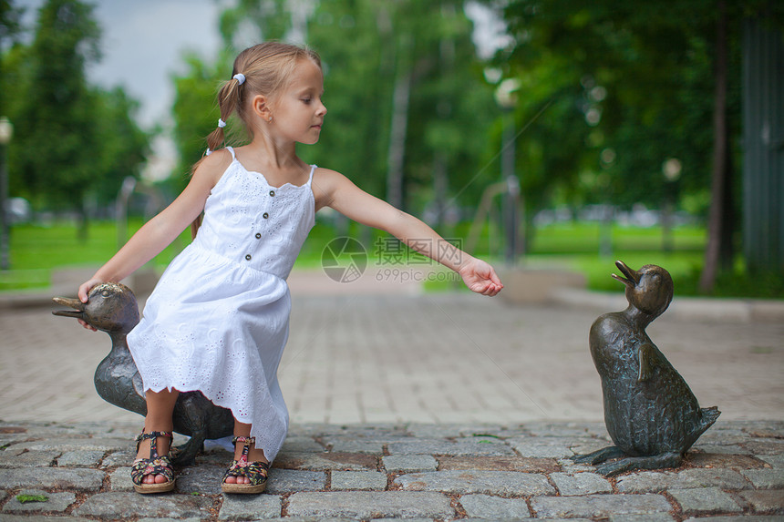 小女孩在公园里喂鸭子的身材图片