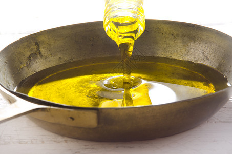 橄榄油倒入黄铜锅高清图片