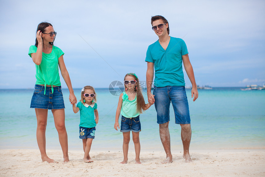 四口的年轻美丽家庭 享受沙滩上放松的快乐父亲孩子们幸福热带妈妈成人孩子旅游父母异国图片
