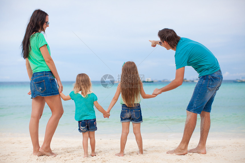 在异国海滩上有两个孩子的美丽家庭的背影女儿热带父亲孩子们旅游海洋幸福女性婴儿情调图片