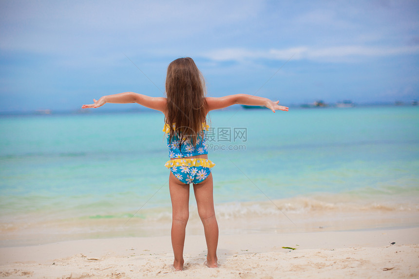 美丽的小女孩张开双臂 站在沙滩上情调假期女儿女性幸福童年异国自由泳装支撑图片