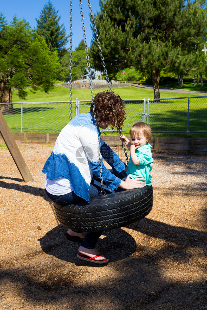 公园的母子母亲儿子秋千轮胎操场后代孩子们乐趣妈妈两个人图片