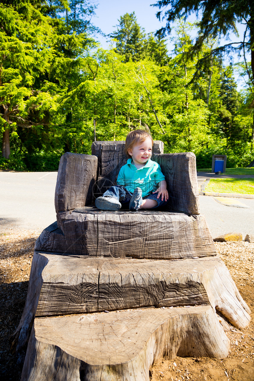男孩坐在跳板椅子上儿子乐趣儿童操场男生公园王座脚步孩子衬衫图片