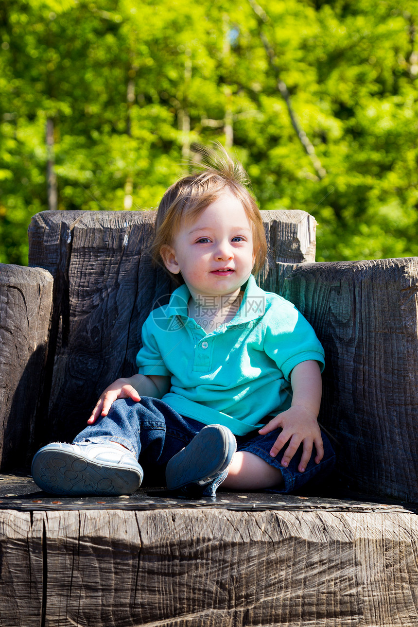 男孩坐在跳板椅子上儿子孩子们座位衬衫孩子乐趣木头操场树桩儿童图片