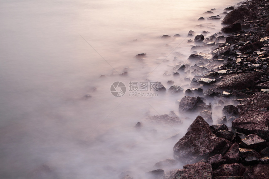 日落时的海海岸波浪和岩石图片