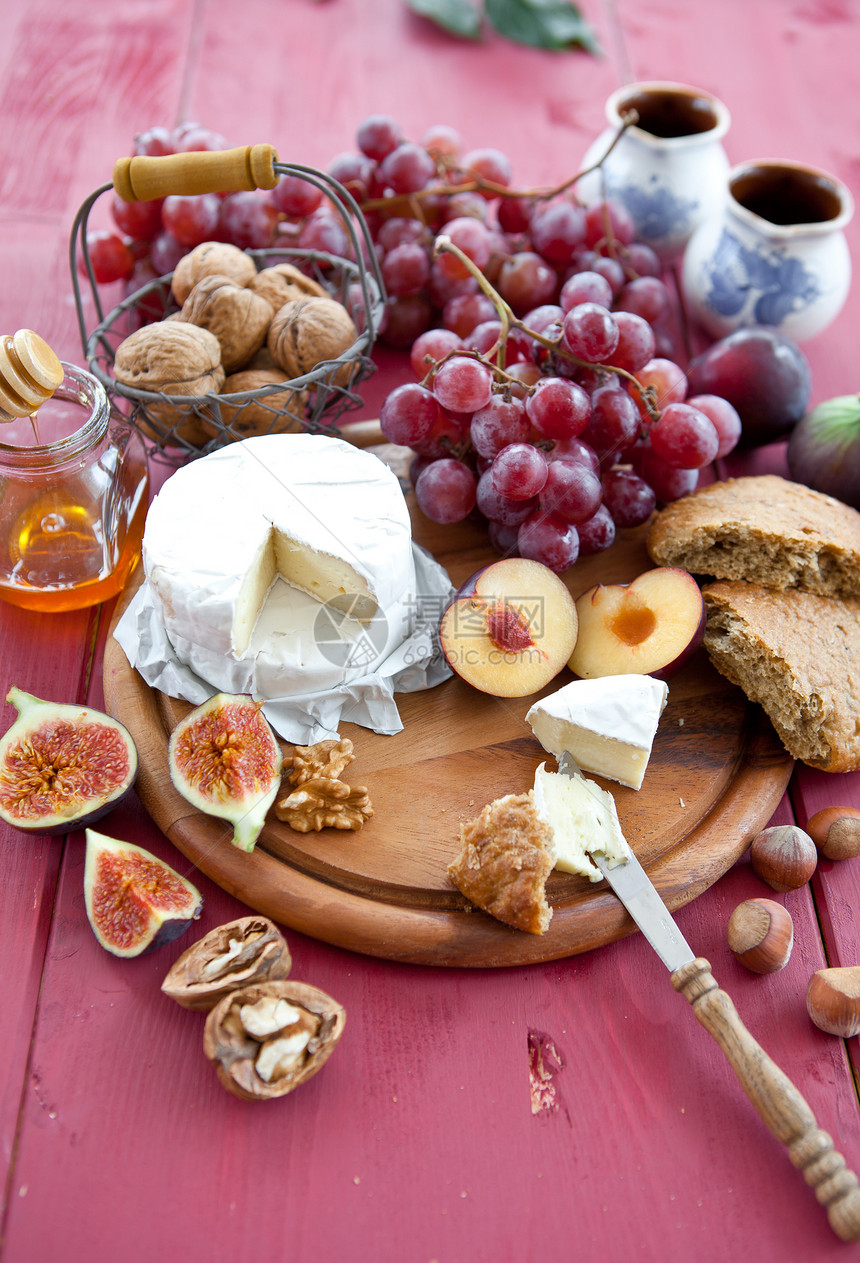 面包 奶酪和红葡萄照片榛子砧板生产篮子红色午餐乡村水果小吃图片