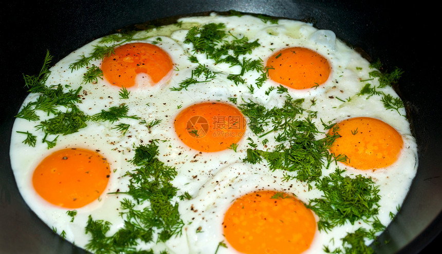 煎鸡蛋在炉子里黑色食物蛋黄黄色平底锅香草图片