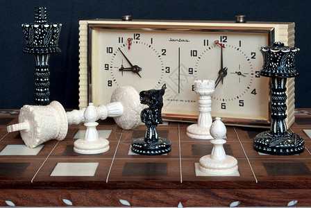 棋盘上黑与白有钟的象棋游戏黑与白象牙派对棋子竞赛棋盘运动手表比赛背景