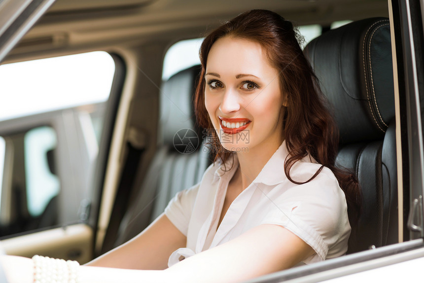 女青年在展厅的新车里学习驾驶汽车司机车辆考试旅行微笑女孩学习者图片