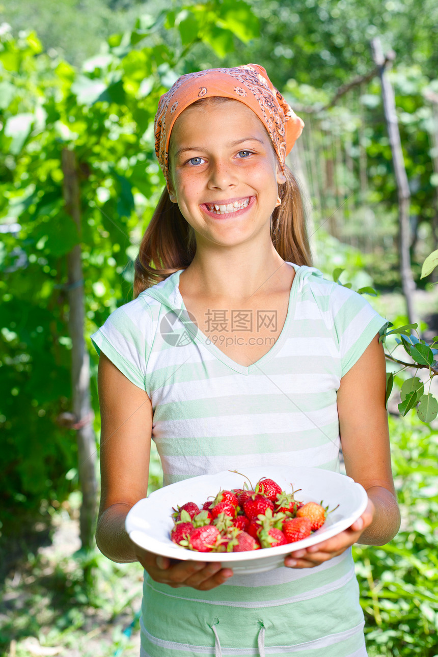 女孩拿着草莓食物甜点水果孩子维生素光泽度花园享受女性小吃图片