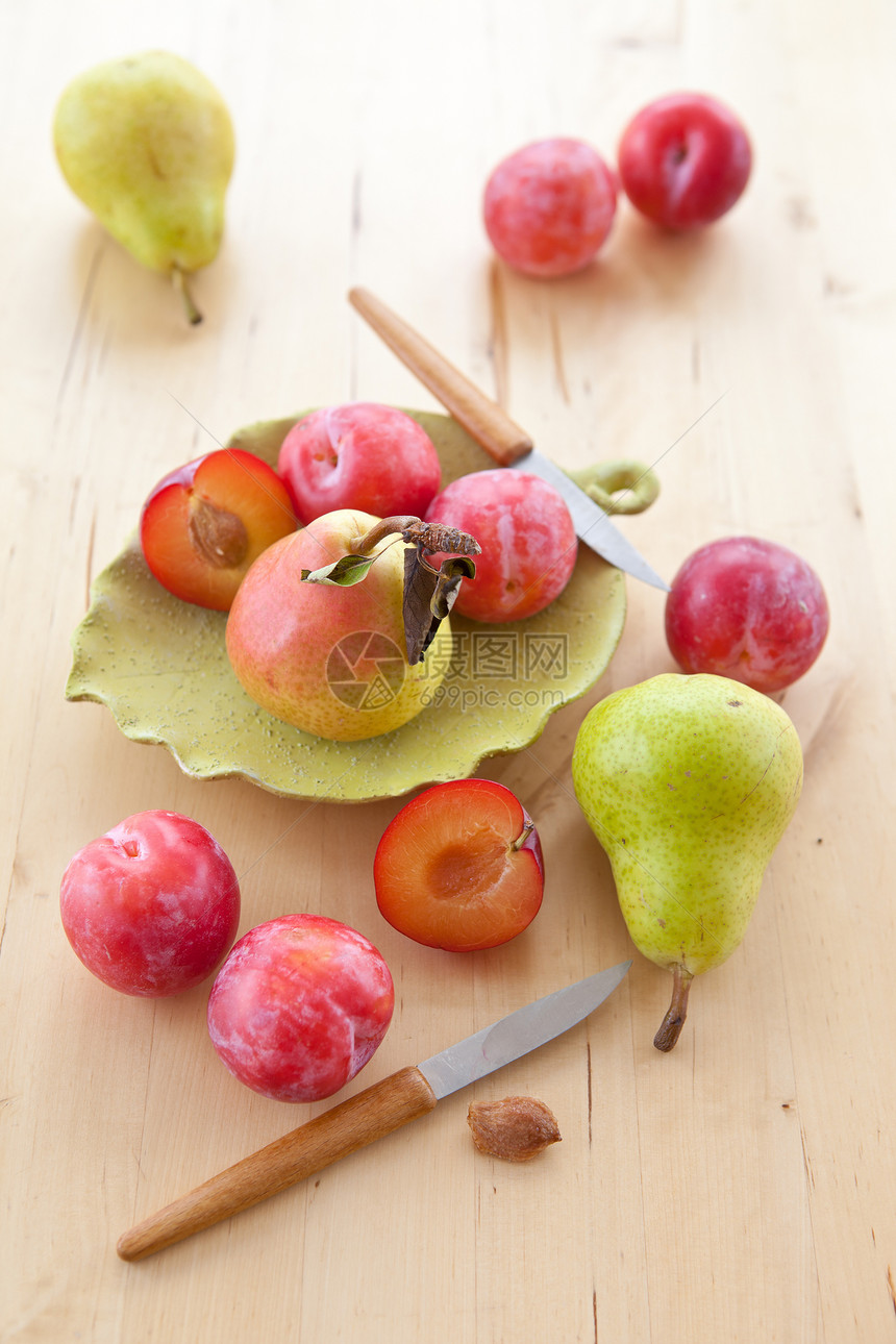 新鲜成熟的李子 苹果和梨桌子糖浆红色绿色树叶盘子图片