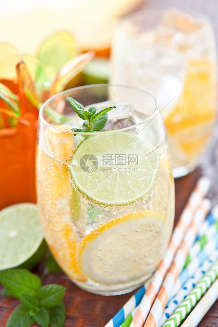 冷饮柠檬和橙子冰块玻璃绿色条纹吸管橘子泉水薄荷饮料茶点图片