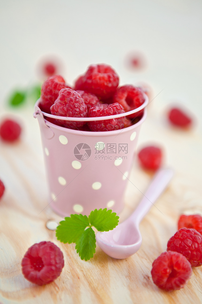 新鲜果子在小旧水桶里粉色浆果覆盆子红色树叶叶子桌子果味水果勺子图片