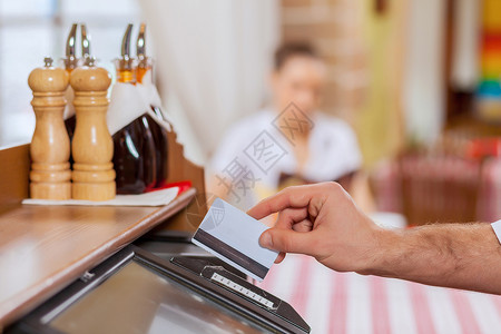 收银服务员收银手的特写卡片收据零售机器柜台磁条食物店铺休息餐厅背景
