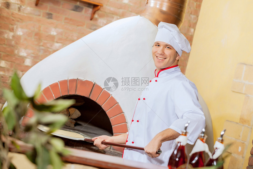 年轻男厨师烹饪火炉烘烤木板餐厅糕点面包食物男性烤箱图片