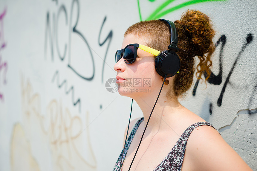 听音乐的现代年轻女青春美丽时尚女士音乐发型潮人日常生活耳机图片