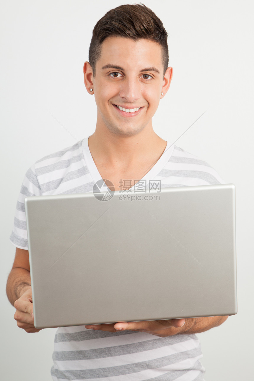 年轻人微笑并使用笔记本电脑作业男人学习家庭学生女性图片