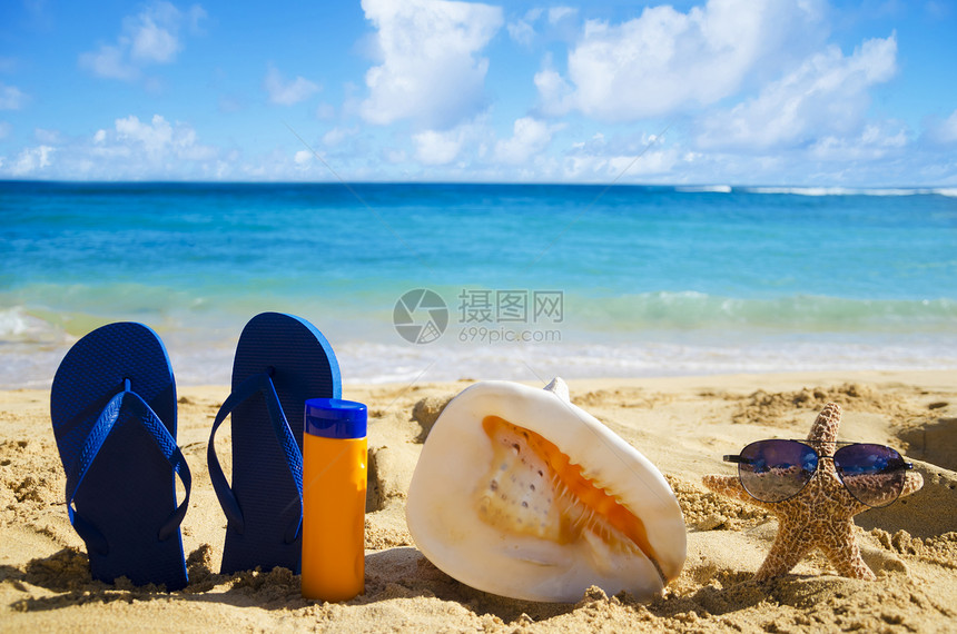 沙沙滩上漂浮 贝壳 防晒霜和海星图片
