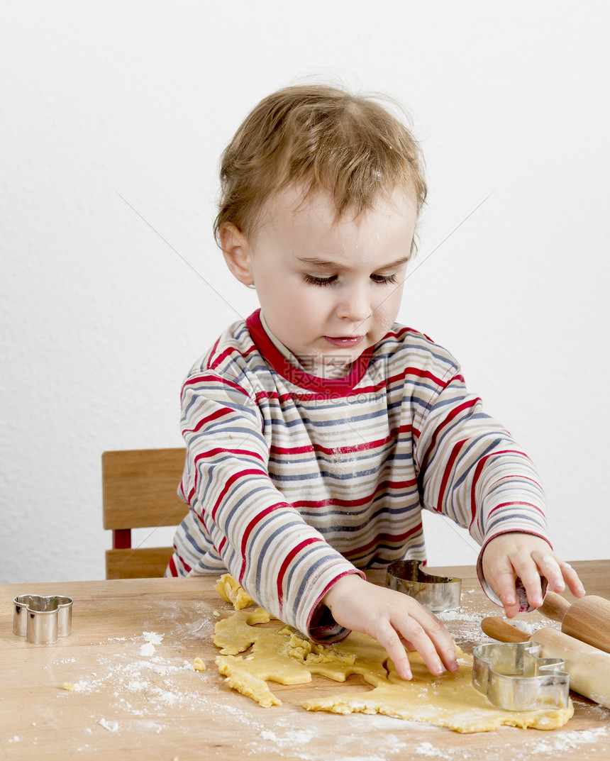 儿童在做饼干的桌上小女孩厨房工作糕点桌子家庭乐趣面粉木头木材图片