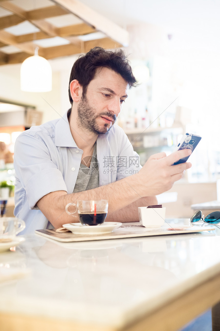 在酒吧的男人在电话咖啡手机早餐胡子沟通城市生活写作短信日常生活图片