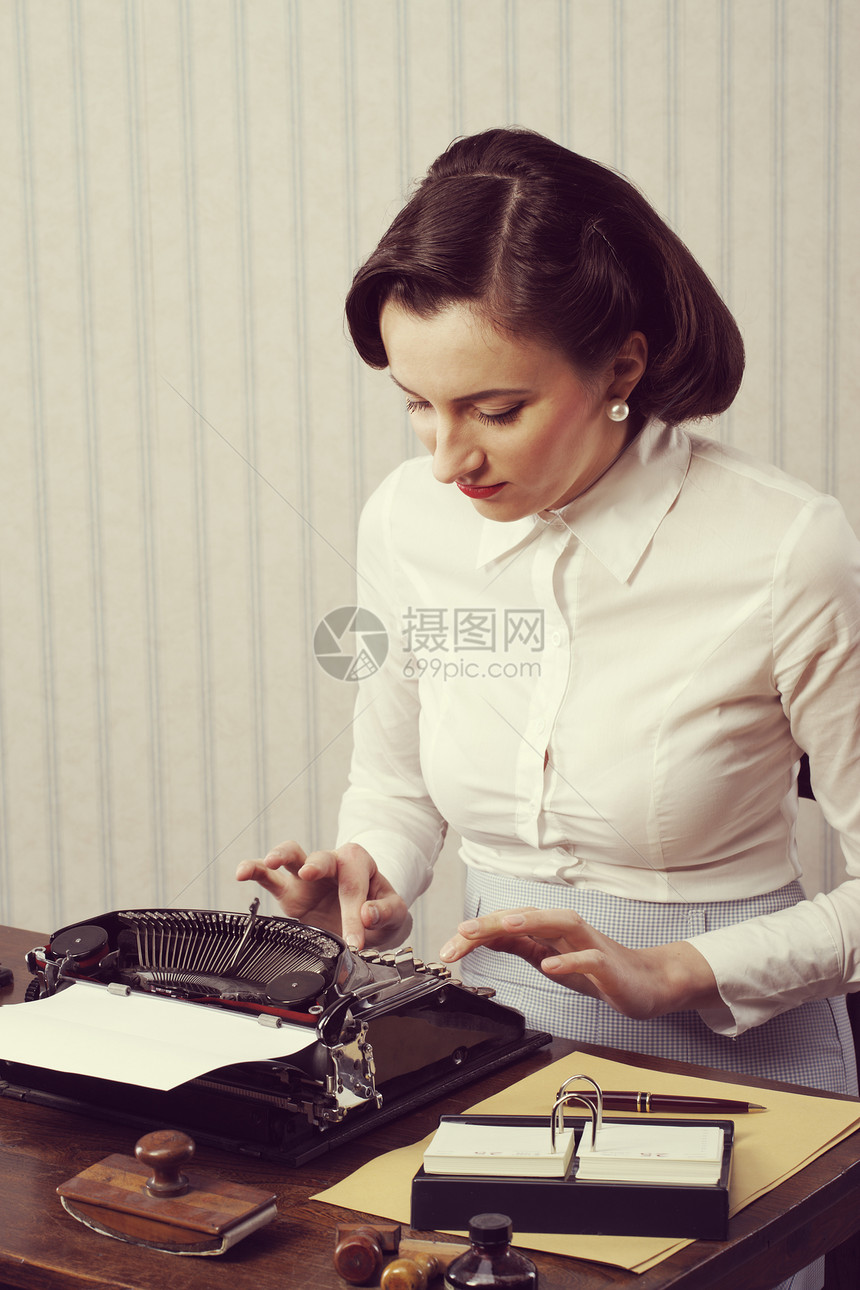 女性在办公室打字人士收腰桌子复古打字机秘书女子复兴风格邮票图片